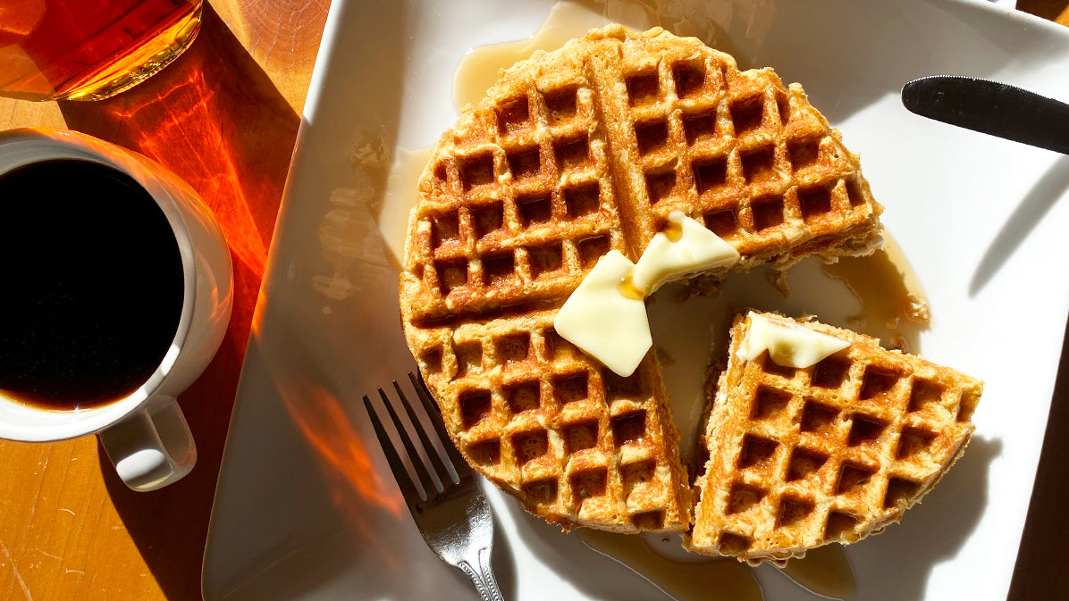 Low-carb lupin waffle next to coffee and sugar-free syrup